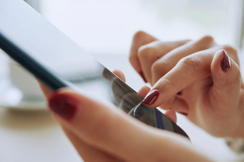 Close-up image of a woman’s hand using an application on her smartphone