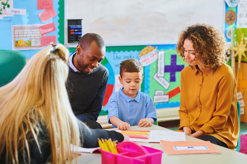 Parents meeting with preschool teacher or coordinator with their child